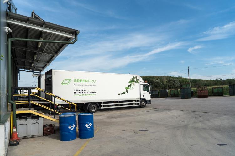Greenpro dobozos tehergépjármű rakodóhelyen, veszélyes hulladékos hordókkal